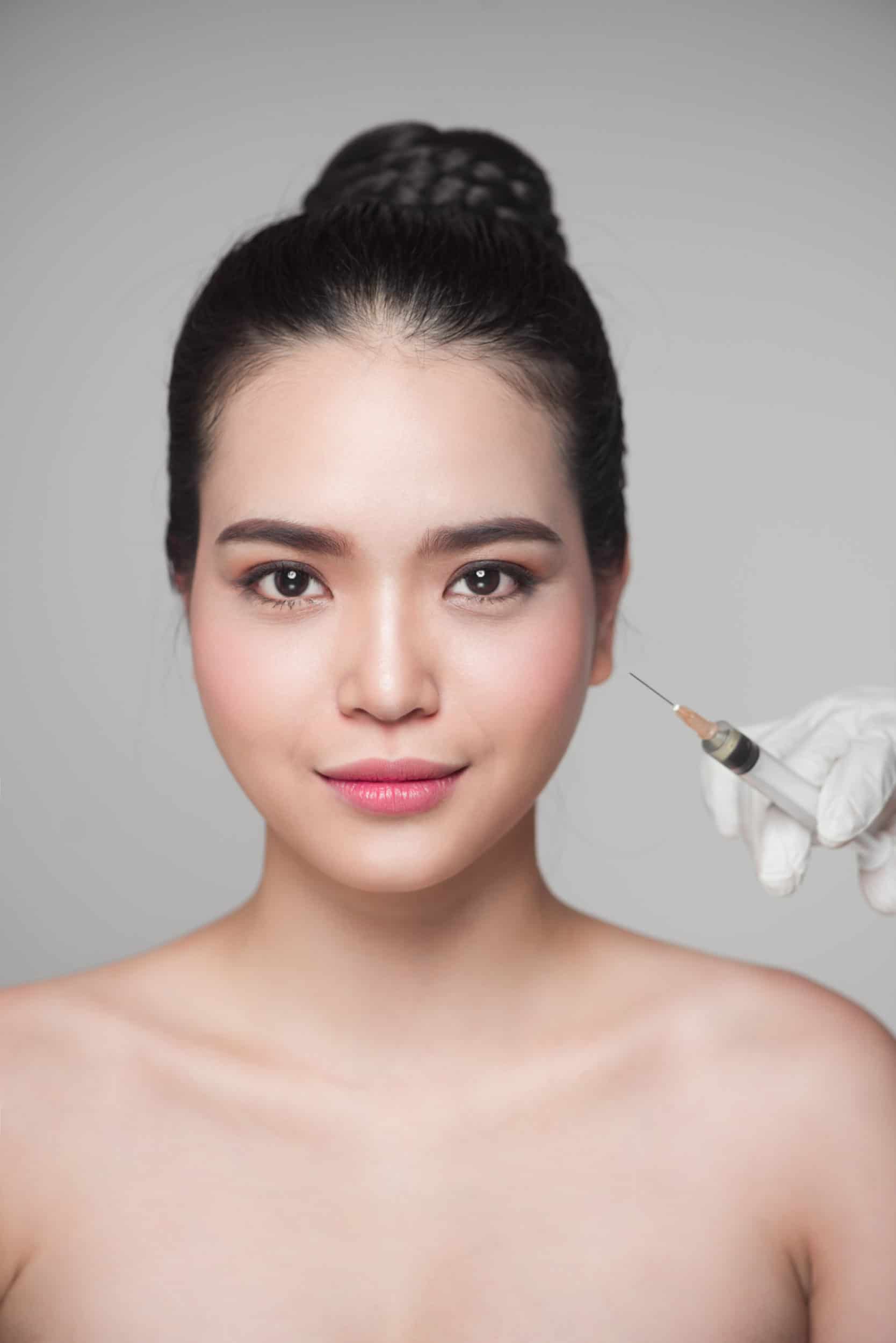 Beautiful asian woman gets deraml filler facial injections. Face aging injection.